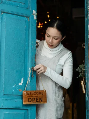 Mujer emprendedora dueña de un negocio abriendo las puertas.